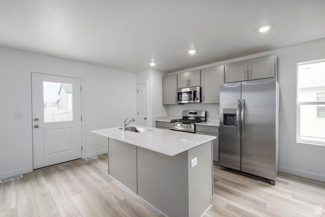 1857 E Bison Dr Unit B217, Eagle Mountain, UT 84005 - kitchen with stainless steel appliances, gray cabinetry, a kitchen island with sink, light wood-type flooring, and light countertops