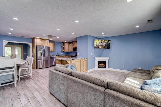 709 N 2200 E, St George, UT 84790 - living area with a textured ceiling, light wood-style flooring, recessed lighting, and a lit fireplace