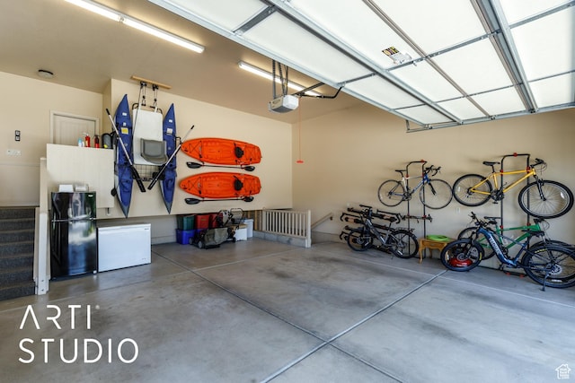 2124 N Heritage Dr, Farr West, UT 84404 - garage with freestanding refrigerator, a garage door opener, and fridge