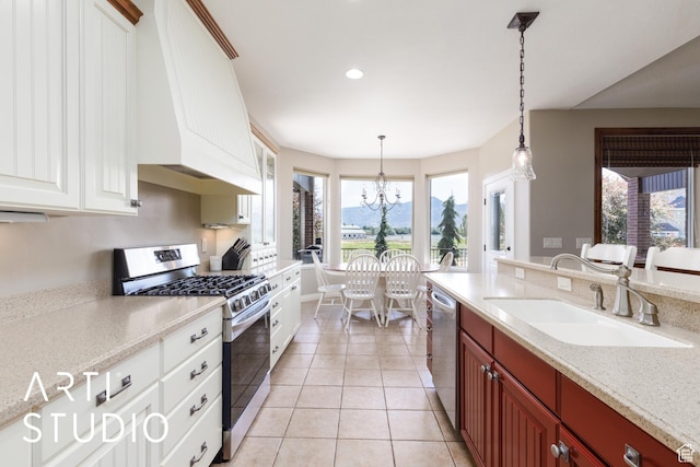 2124 N Heritage Dr, Farr West, UT 84404 - kitchen featuring appliances with stainless steel finishes, custom exhaust hood, a chandelier, light tile patterned flooring, and hanging light fixtures