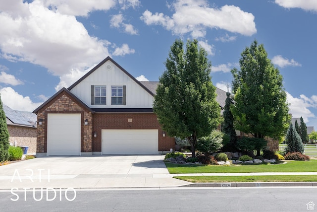 2124 N Heritage Dr, Farr West, UT 84404 - view of front of house featuring board and batten siding, a front lawn, driveway, brick siding, and a garage