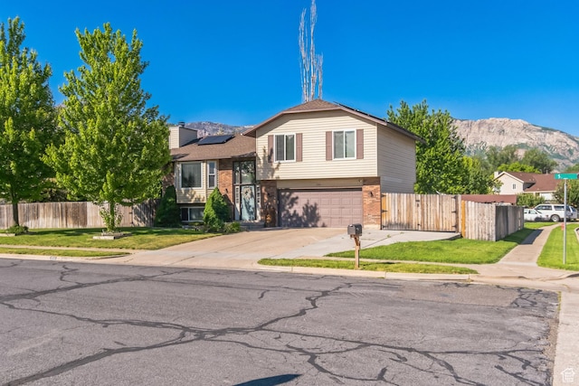 254 W 1600 N, Harrisville, UT 84404 - split level home featuring solar panels, a mountain view, brick siding, and an attached garage