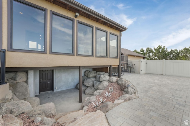 8656 N W Dr E, Eagle Mountain, UT 84005 - view of side of home with stucco siding, a patio, and a gate