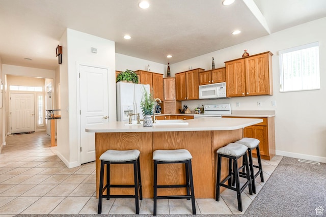 674 E Free Land Ave S, Midvale, UT 84047 - kitchen featuring white appliances, light countertops, light tile patterned floors, a kitchen bar, and plenty of natural light