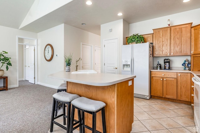 674 E Free Land Ave S, Midvale, UT 84047 - kitchen featuring white fridge with ice dispenser, a kitchen breakfast bar, light countertops, recessed lighting, and brown cabinets