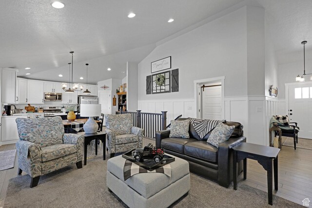 1792 W Norway Spruce Dr, Layton, UT 84041 - living area featuring light wood-type flooring, a chandelier, high vaulted ceiling, recessed lighting, and a wainscoted wall