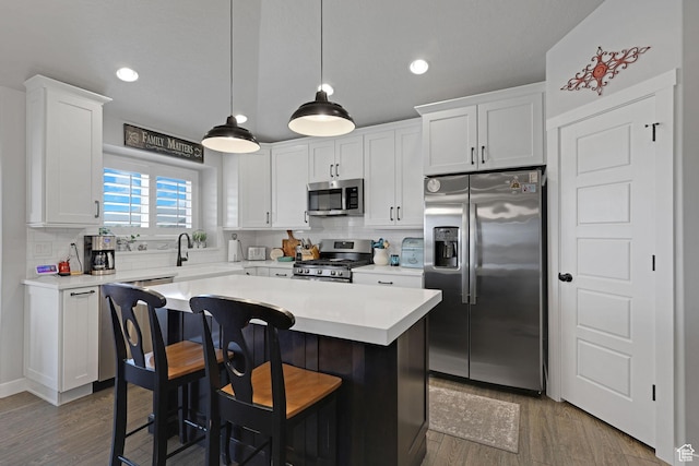 1792 W Norway Spruce Dr, Layton, UT 84041 - kitchen with appliances with stainless steel finishes, tasteful backsplash, white cabinetry, wood finished floors, and recessed lighting