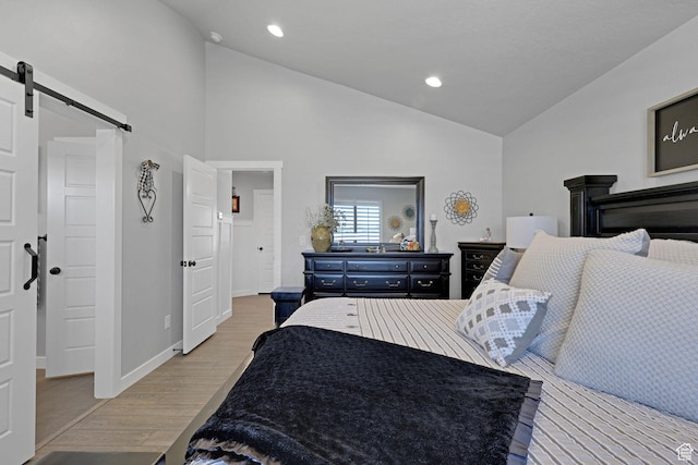 1792 W Norway Spruce Dr, Layton, UT 84041 - bedroom with a barn door, light wood-style floors, recessed lighting, and high vaulted ceiling