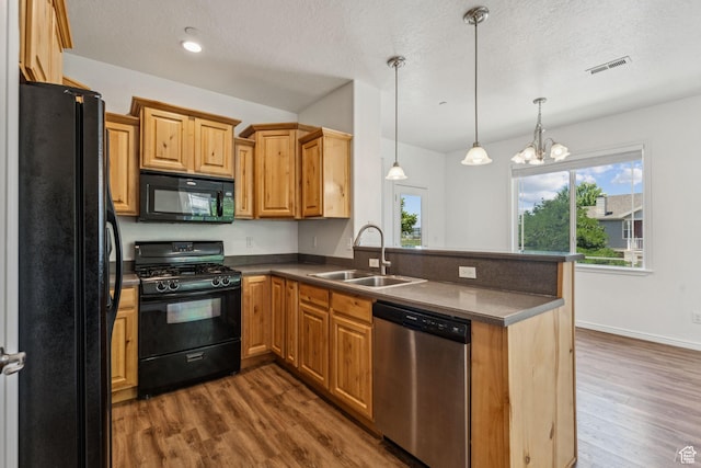 1535 W 80 S, Pleasant Grove, UT 84062 - kitchen featuring black appliances, dark wood finished floors, dark countertops, a peninsula, and pendant lighting