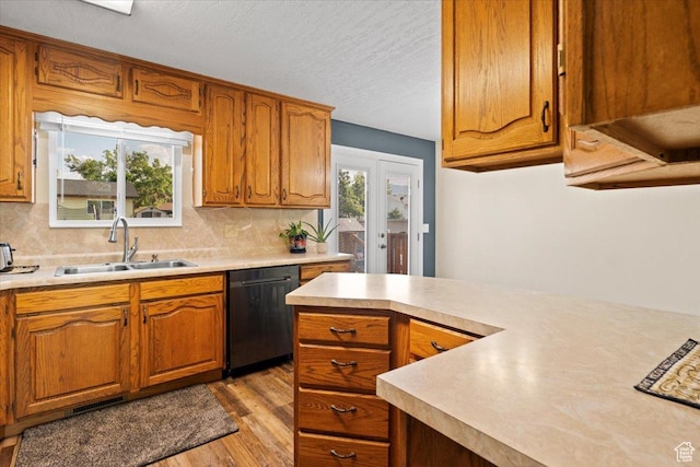 7351 W Zana Ln, Magna, UT 84044 - kitchen with dishwashing machine, light countertops, light wood finished floors, tasteful backsplash, and a textured ceiling