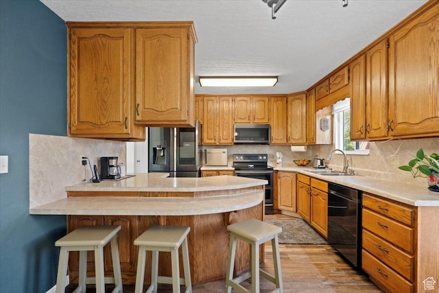 7351 W Zana Ln, Magna, UT 84044 - kitchen with stainless steel appliances, a peninsula, light countertops, backsplash, and a textured ceiling