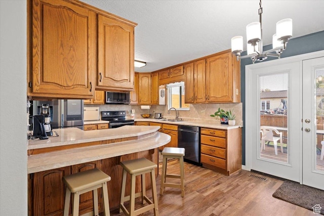 7351 W Zana Ln, Magna, UT 84044 - kitchen featuring appliances with stainless steel finishes, a peninsula, light countertops, light wood-style flooring, and tasteful backsplash