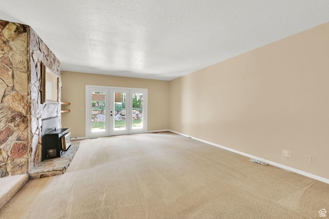 293 E 5450 S Unit 19, Washington Terrace, UT 84405 - unfurnished living room with a wood stove, light carpet, french doors, and a textured ceiling