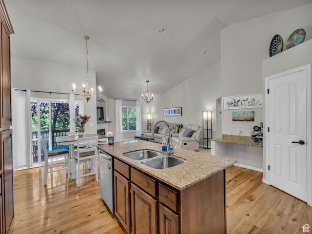 4587 W Flintlock Way, Herriman, UT 84096 - kitchen with dishwasher, a chandelier, a center island with sink, light wood finished floors, and brown cabinetry