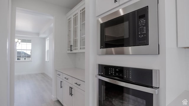 903 W Fallow Dr Unit 212, Saratoga Springs, UT 84045 - kitchen featuring built in microwave, oven, light wood-style flooring, and white cabinetry