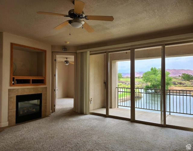 225 N Country Ln Unit 5, St George, UT 84770 - unfurnished living room featuring a ceiling fan, carpet, a textured ceiling, and a tiled fireplace