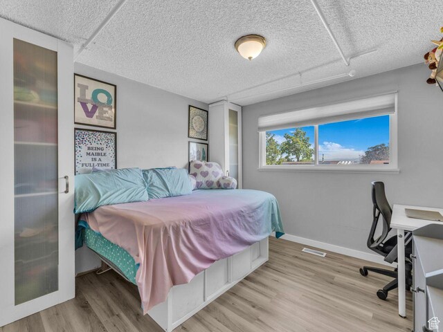 4273 W Annapolis Dr S, West Valley City, UT 84120 - bedroom with wood finished floors, a textured ceiling, and a desk