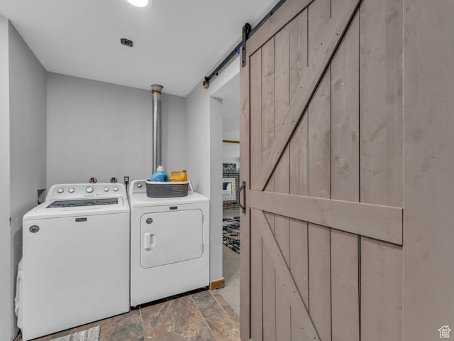 4273 W Annapolis Dr S, West Valley City, UT 84120 - washroom featuring washer and clothes dryer, a barn door, and light stone finish floors