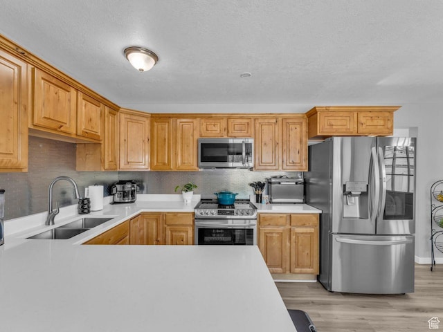 4273 W Annapolis Dr S, West Valley City, UT 84120 - kitchen featuring stainless steel appliances, light countertops, light wood-type flooring, tasteful backsplash, and a textured ceiling