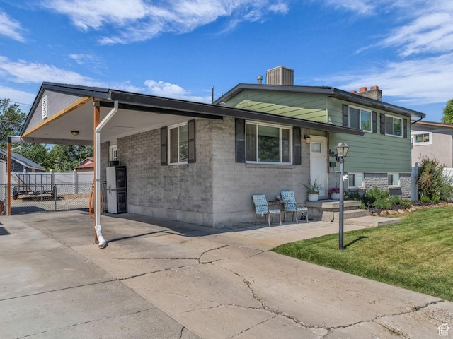 4273 W Annapolis Dr S, West Valley City, UT 84120 - view of front of home with a chimney, an attached carport, driveway, brick siding, and a gate