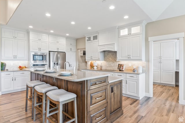 1155 S Eagle Nest Dr, Woodland Hills, UT 84653 - kitchen with stainless steel appliances, a kitchen bar, decorative backsplash, white cabinetry, and recessed lighting