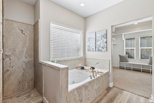 1155 S Eagle Nest Dr, Woodland Hills, UT 84653 - bathroom featuring healthy amount of natural light, a tub with jets, wood finished floors, and a shower