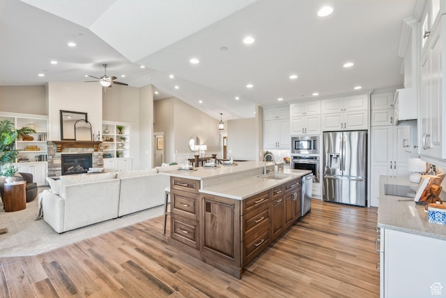 1155 S Eagle Nest Dr, Woodland Hills, UT 84653 - kitchen with stainless steel appliances, white cabinetry, a ceiling fan, a large island, and light wood-style flooring