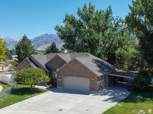 643 E 140 N, American Fork, UT 84003 - view of front of house featuring concrete driveway, brick siding, a garage, a mountain view, and a chimney