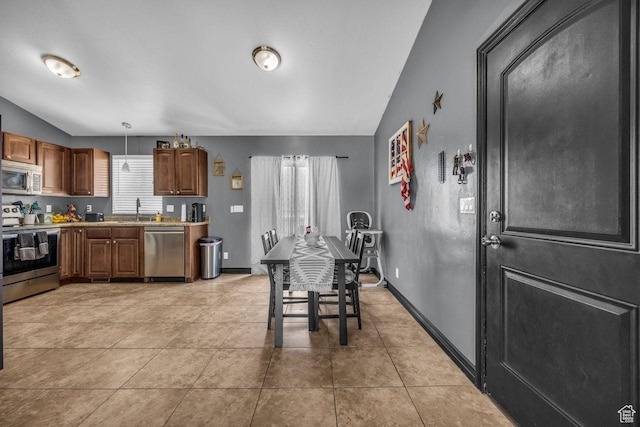 726 S 1050 W, Tooele, UT 84074 - kitchen with appliances with stainless steel finishes, lofted ceiling, light countertops, light tile patterned flooring, and hanging light fixtures