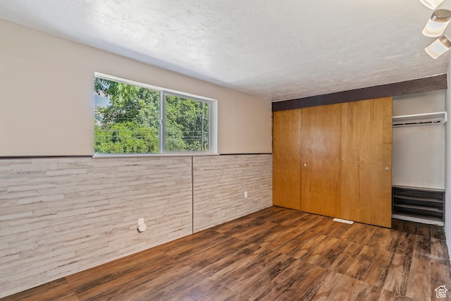 641 S 500 W, Brigham City, UT 84302 - unfurnished bedroom with wood finished floors, a closet, wainscoting, and wood walls