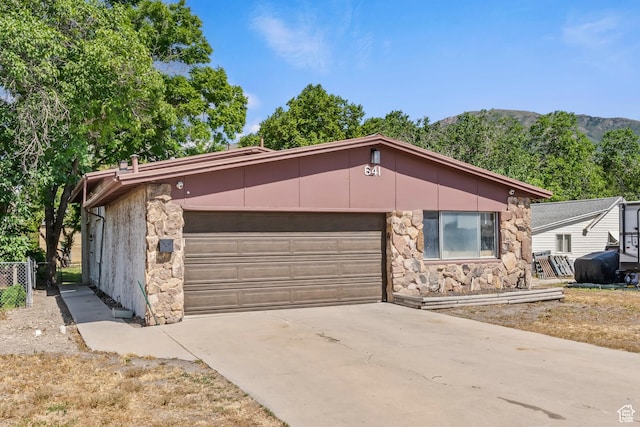 641 S 500 W, Brigham City, UT 84302 - view of front of house with stone siding, a garage, concrete driveway, and a mountain view