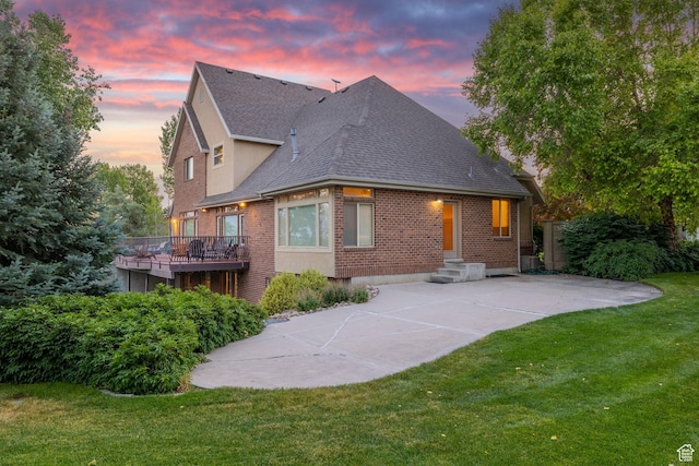 192 E 2200 N, Lehi, UT 84043 - back of property at dusk with brick siding, roof with shingles, and a yard