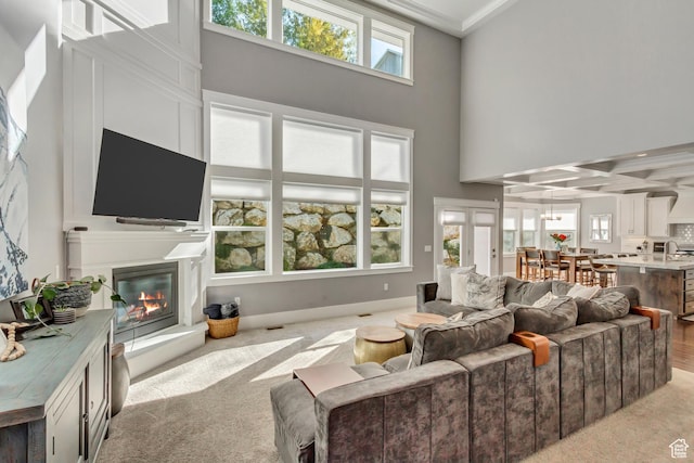 467 E Island View Cir N, Farmington, UT 84025 - living room featuring a glass covered fireplace, healthy amount of natural light, a high ceiling, light colored carpet, and crown molding