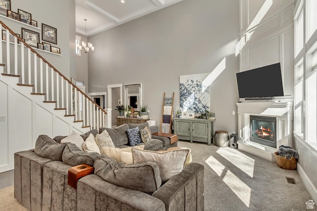 467 E Island View Cir N, Farmington, UT 84025 - living room featuring a towering ceiling, a glass covered fireplace, stairs, a chandelier, and light colored carpet