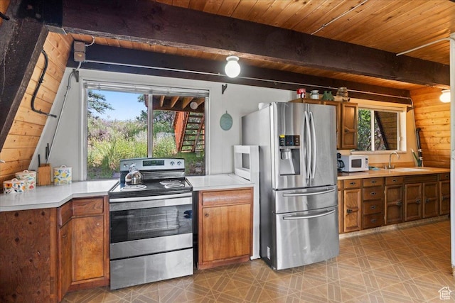 9406 Deer Creek Dr Unit 1074, Heber City, UT 84032 - kitchen with stainless steel appliances, plenty of natural light, a wooden ceiling with exposed beams, and brown cabinetry