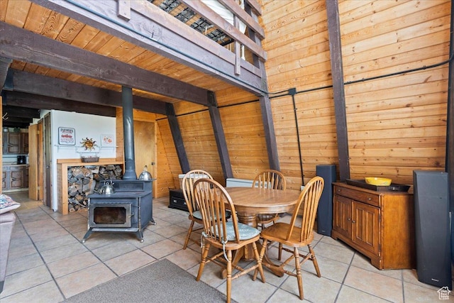 9406 Deer Creek Dr Unit 1074, Heber City, UT 84032 - dining area featuring a wood stove, wood walls, light tile patterned floors, and a wood ceiling with exposed beams