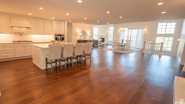 2295 E Woodchuck Way, Sandy, UT 84093 - kitchen featuring stainless steel oven, premium range hood, open floor plan, a kitchen island with sink, and light countertops