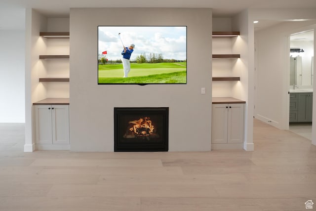 10135 E Clubhouse Rd, Heber City, UT 84032 - unfurnished living room featuring a warm lit fireplace, built in features, light wood-style floors, and recessed lighting