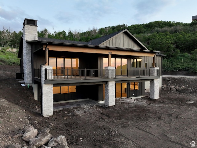 10135 E Clubhouse Rd, Heber City, UT 84032 - back of house featuring a chimney, a balcony, board and batten siding, and a forest view