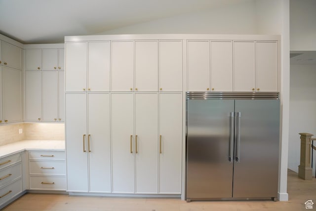 10135 E Clubhouse Rd, Heber City, UT 84032 - kitchen with built in fridge, light countertops, lofted ceiling, light wood-style floors, and tasteful backsplash