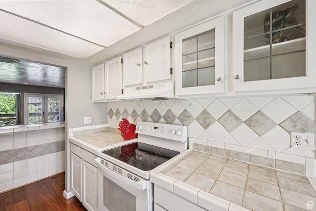 5249 S Gravenstein Park, Murray, UT 84123 - kitchen with electric range, under cabinet range hood, white cabinetry, tile countertops, and glass insert cabinets