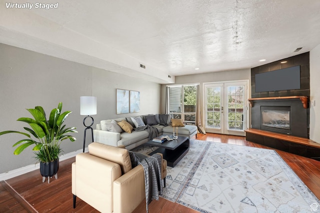 5249 S Gravenstein Park, Murray, UT 84123 - living room with hardwood / wood-style flooring, a tiled fireplace, and a textured ceiling