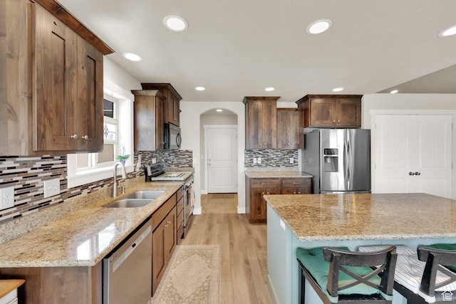5295 S 4425 W, Hooper, UT 84315 - kitchen with appliances with stainless steel finishes, light wood finished floors, a breakfast bar area, light stone counters, and recessed lighting