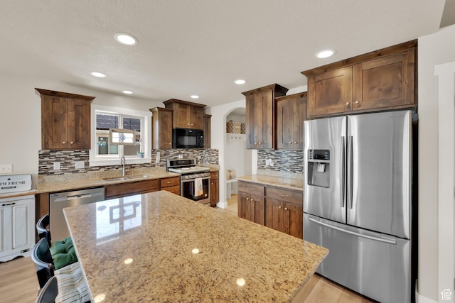 5295 S 4425 W, Hooper, UT 84315 - kitchen with appliances with stainless steel finishes, arched walkways, backsplash, light stone countertops, and recessed lighting