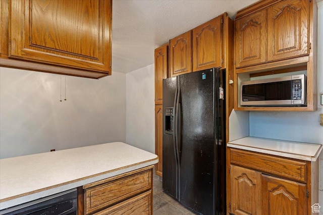 457 E 1750 N, North Ogden, UT 84414 - kitchen with black refrigerator with ice dispenser, stainless steel microwave, brown cabinets, light countertops, and tile patterned flooring