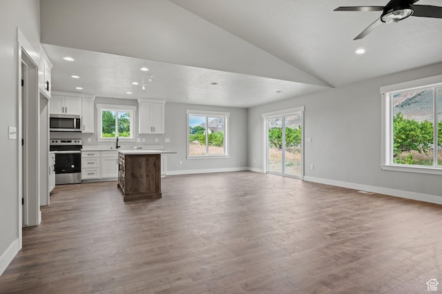9420 N 5600, Elwood, UT 84337 - unfurnished living room with healthy amount of natural light, vaulted ceiling, a ceiling fan, dark wood-type flooring, and recessed lighting