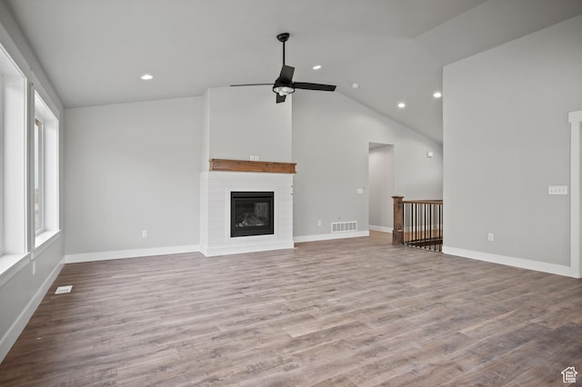 9420 N 5600, Elwood, UT 84337 - unfurnished living room with a ceiling fan, vaulted ceiling, recessed lighting, a glass covered fireplace, and wood finished floors