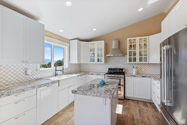 775 N 500 E, Spring City, UT 84662 - kitchen featuring stainless steel appliances, wall chimney range hood, vaulted ceiling, light wood finished floors, and decorative backsplash