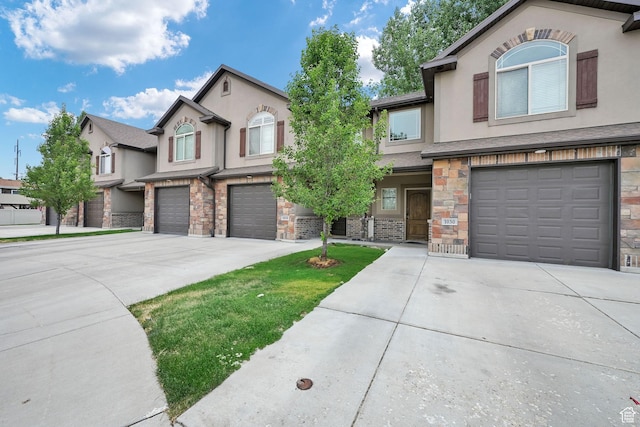 1028 W 950 N, Layton, UT 84041 - view of front of property featuring a garage, driveway, stone siding, and stucco siding