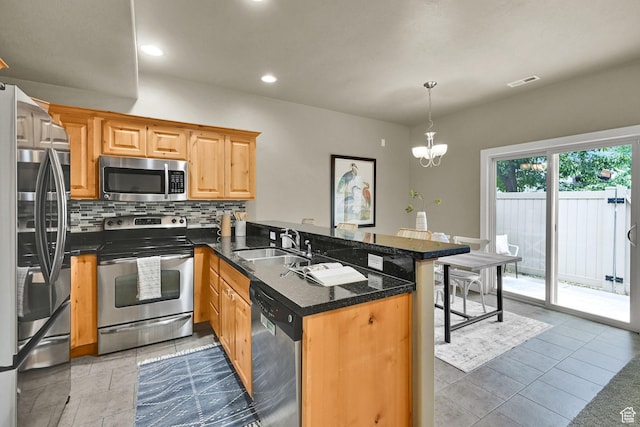 1028 W 950 N, Layton, UT 84041 - kitchen with appliances with stainless steel finishes, a peninsula, decorative backsplash, recessed lighting, and a chandelier